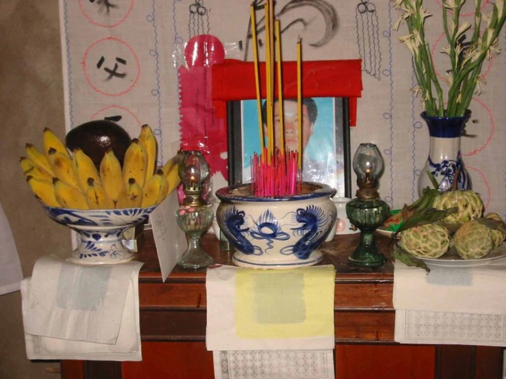 a table set up with various bowls and vases of various fruits and vegetables