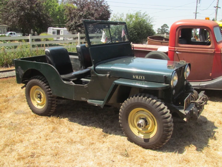 two antique cars parked next to a pick up truck