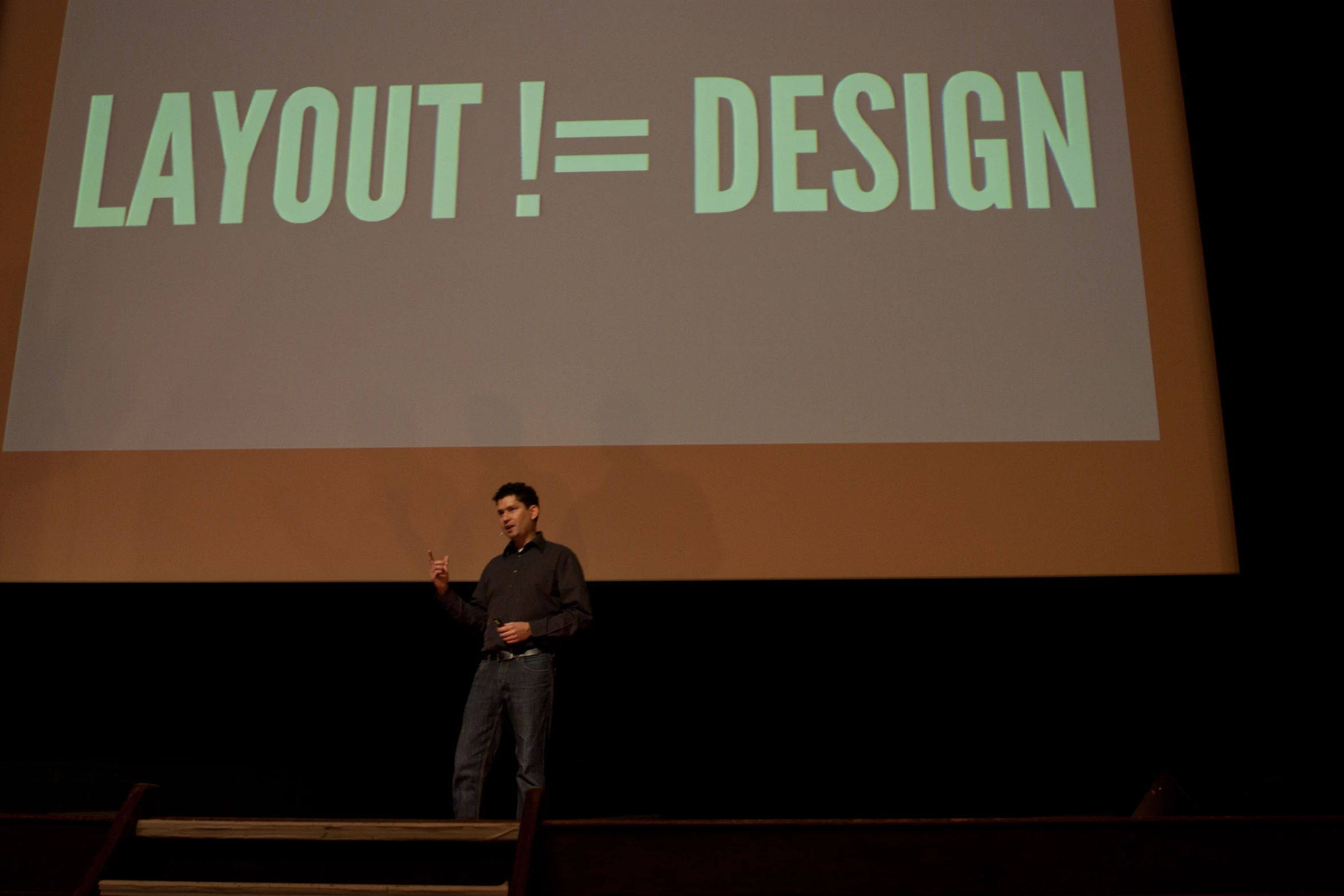 a man stands in front of a projection screen giving a presentation