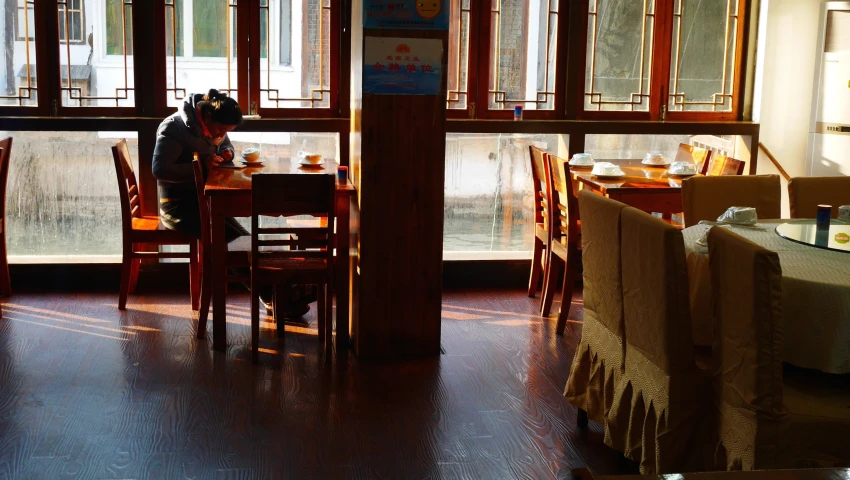 the silhouette of the person sits at the table behind him as if eating a meal