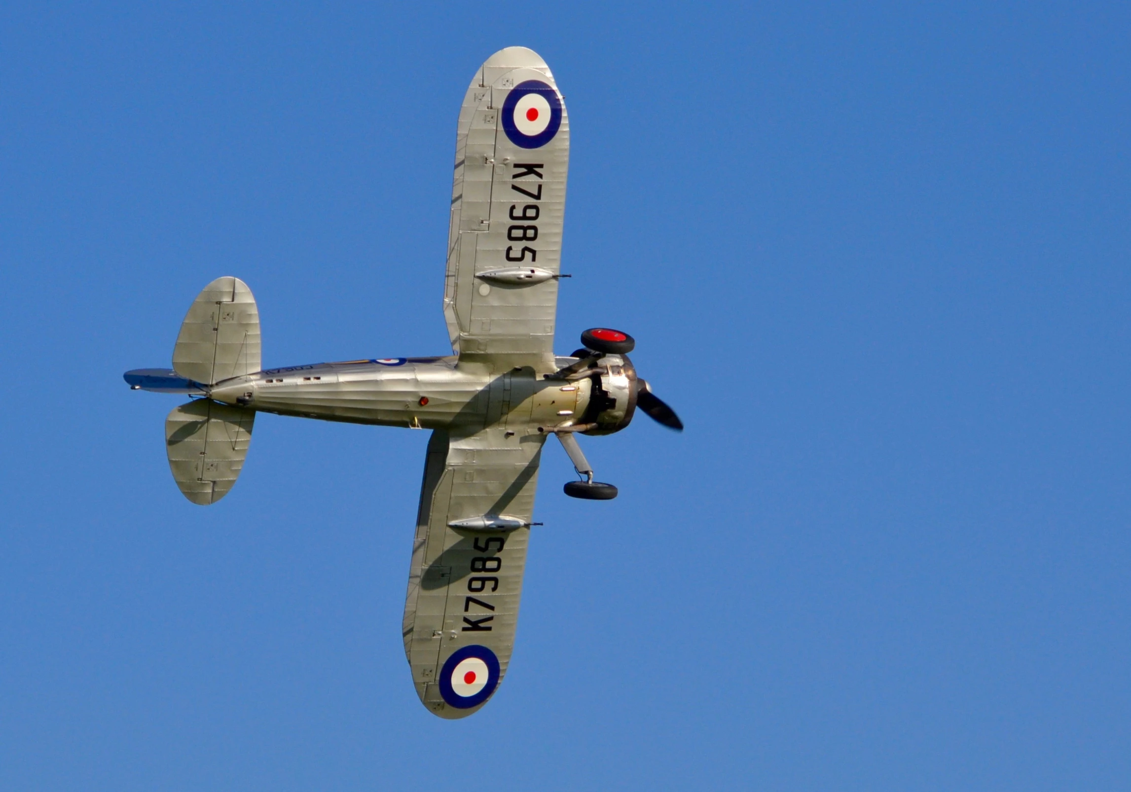 a small old airplane flying high up in the sky