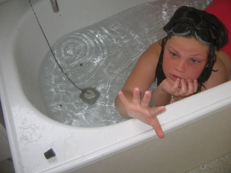 a little girl with goggles taking a bath