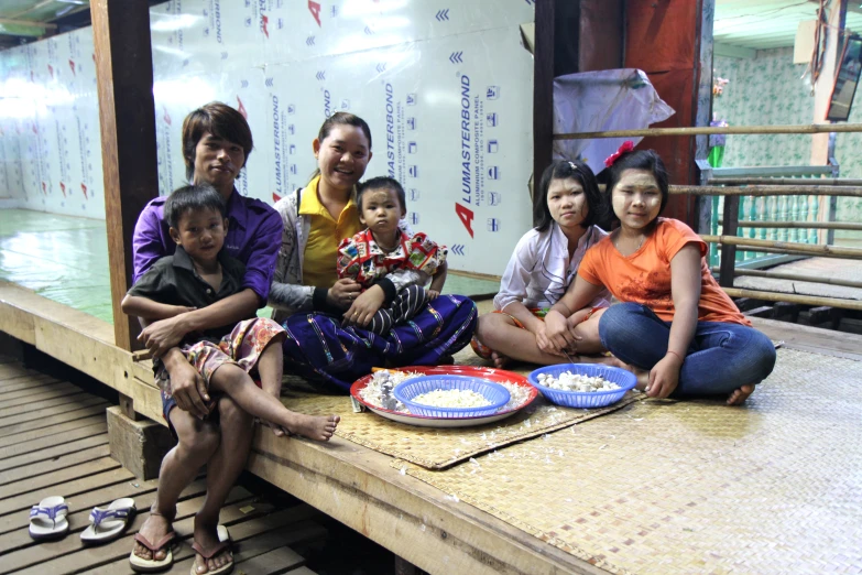 people sitting on a bench with plates of food