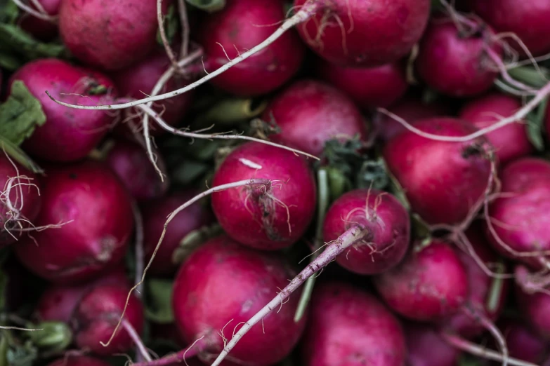 a pile of red radishes piled on top of each other