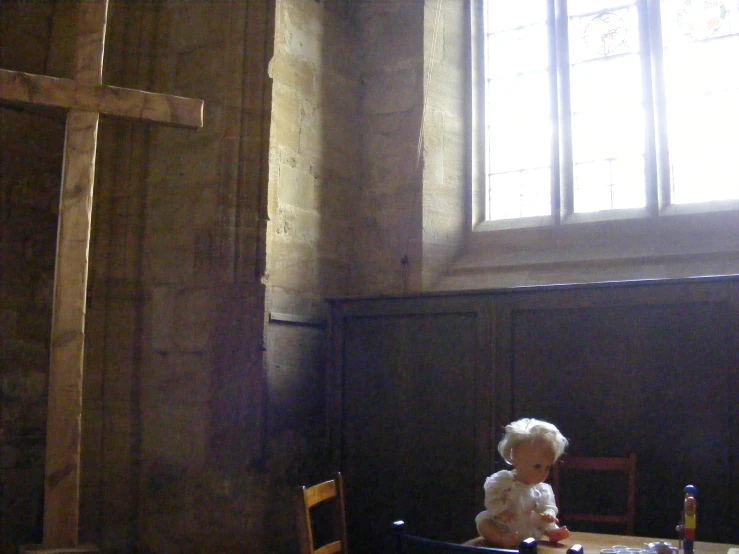  sitting on a wooden chair looking at the cross in an old - fashioned church