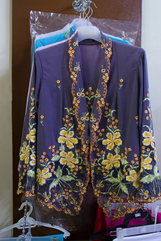 a purple blouse that has a bunch of flowers on it