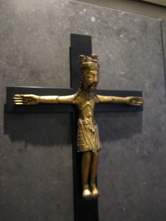 a statue of jesus on the cross against a black wall