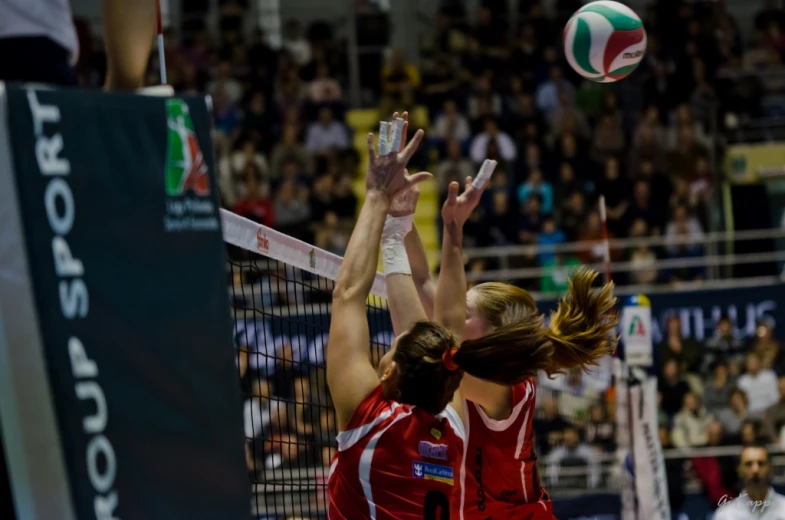 two women who are playing volleyball together