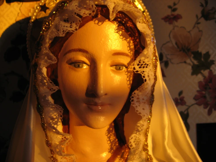 a close up of a yellow mannequin wearing a dress with white and red lace