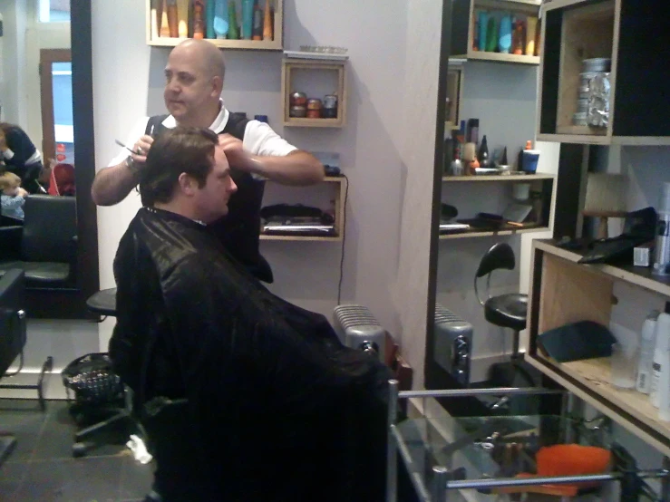 two men are getting their hair done in a salon