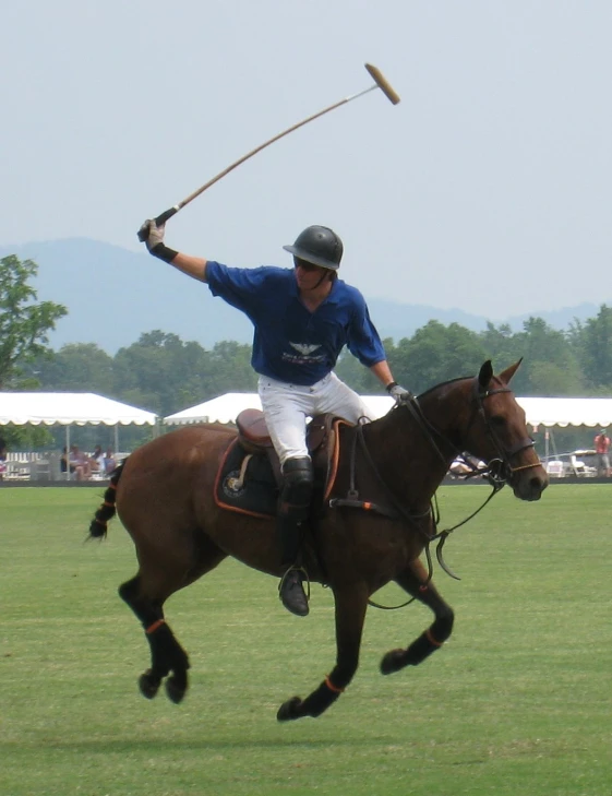 a man in white is riding a brown horse