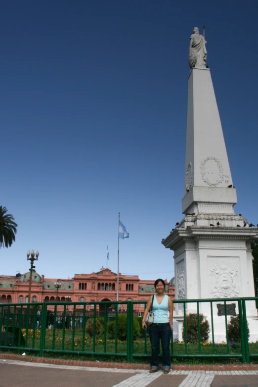 a woman is standing next to the monument