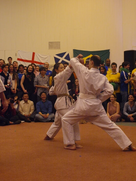 two people performing karate in front of a crowd