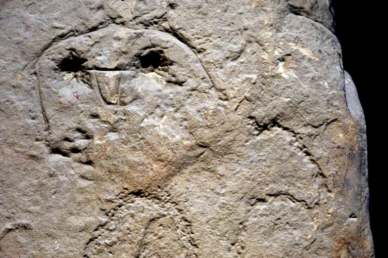 a rock with drawings on the side and writing on the side