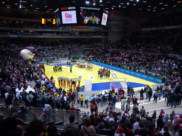 a big crowd in a large stadium watches the basketball game