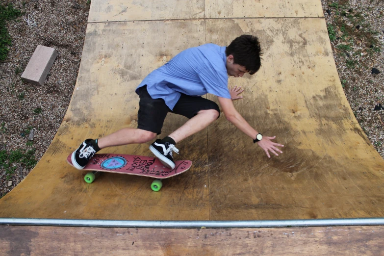 a boy riding a skateboard on top of a wooden ramp