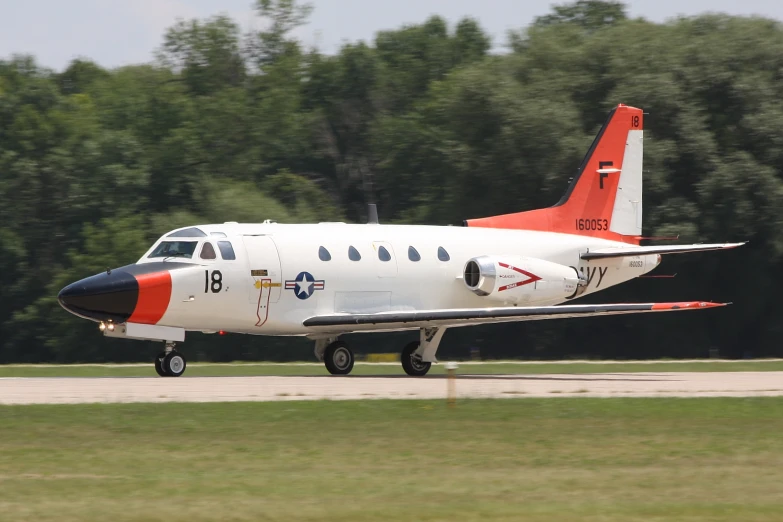 an airplane with red accents landing on a runway