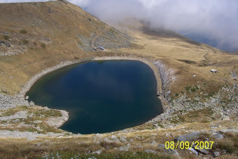 the sky is filled with clouds and a mountain lake