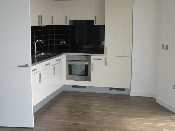 a large empty kitchen with all white cabinets