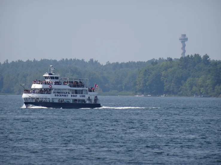 a boat is traveling across the water near a large tower