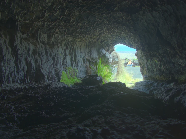 a person standing inside of a cave near water