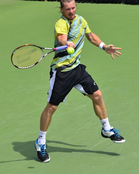 a person wearing black shorts while holding a tennis racquet