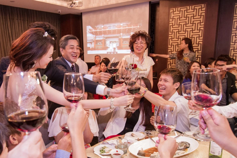 a group of people are toasting at a party