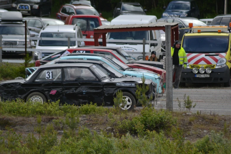 an accident scene of three cars with emergency vehicles in the background