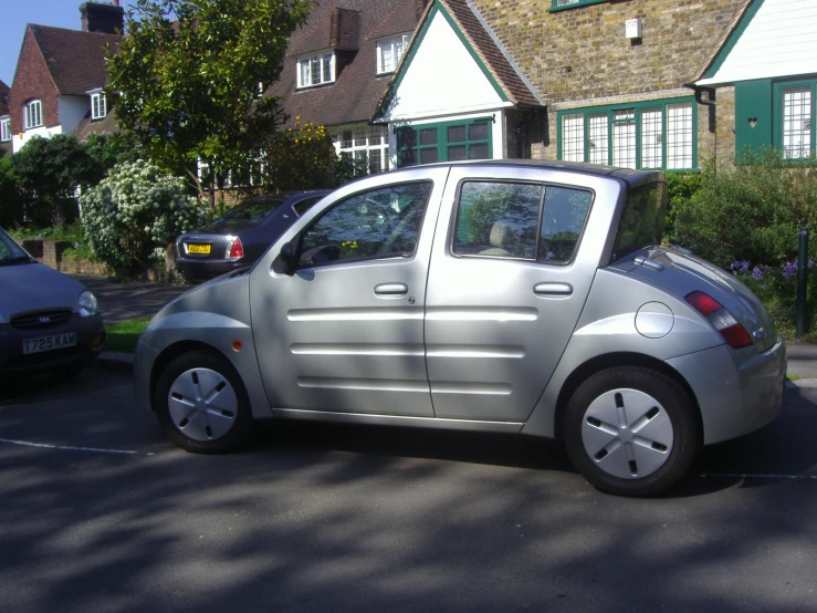 a small silver car parked in a lot of cars