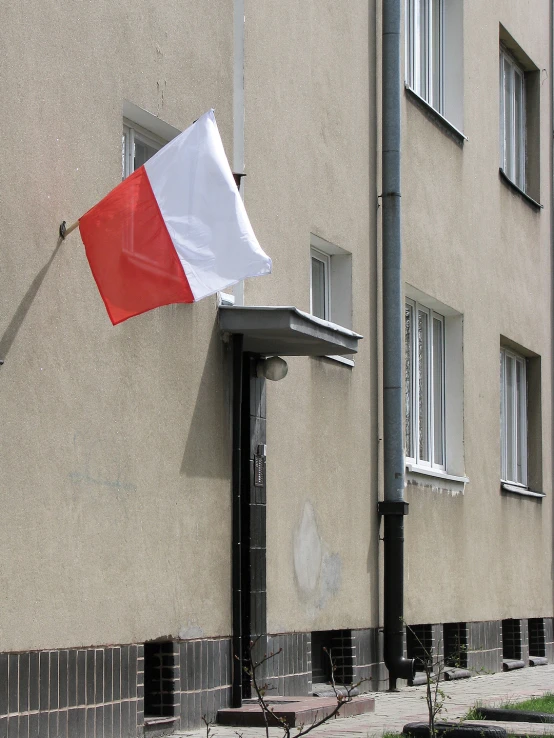 a red, white and blue flag is hanging off a building