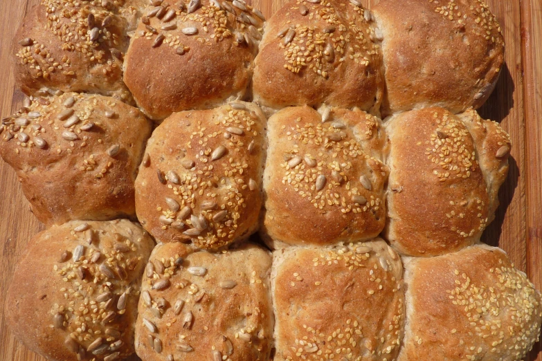 a large batch of seed bread rolls on a  board