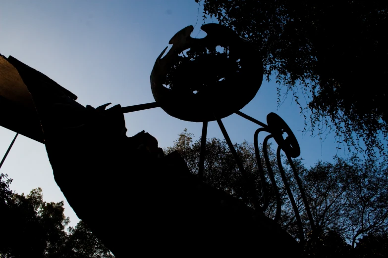 the silhouette of a metal sculpture with a sky background