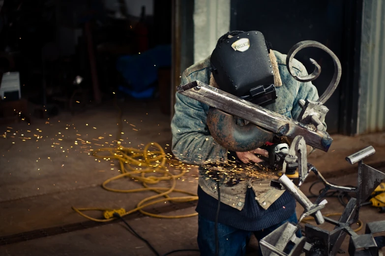 a worker welding sparks with a machine