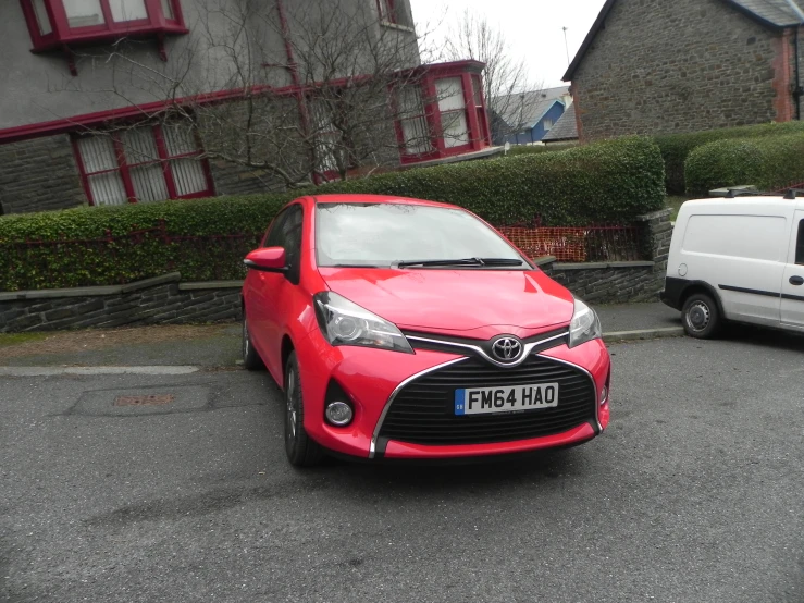 a red toyota focus parked in front of another car