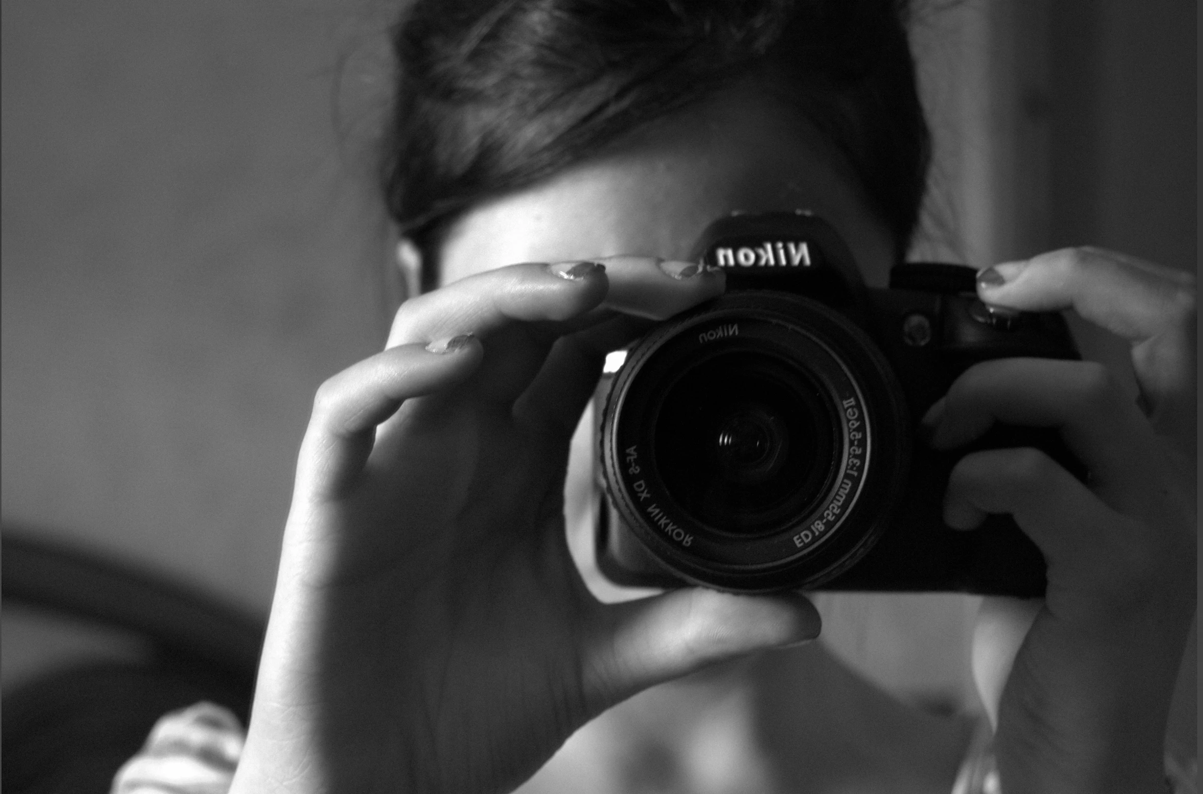 a woman taking a picture with a digital camera