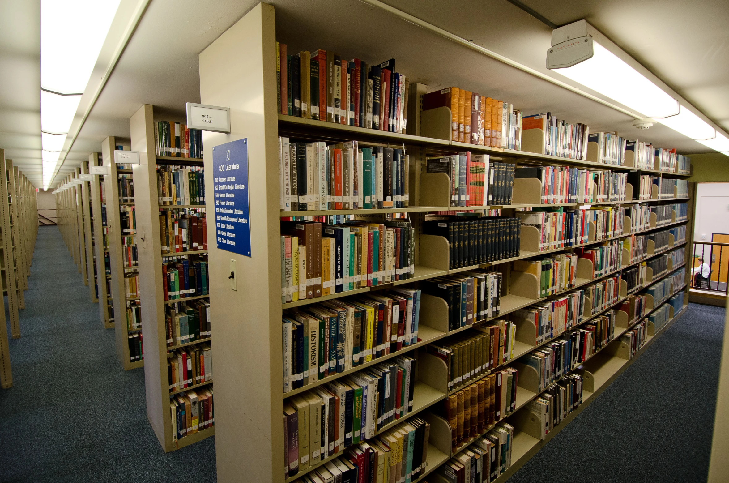 shelves full of books and many stacks of books