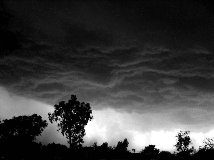 a dark sky is shown over a field