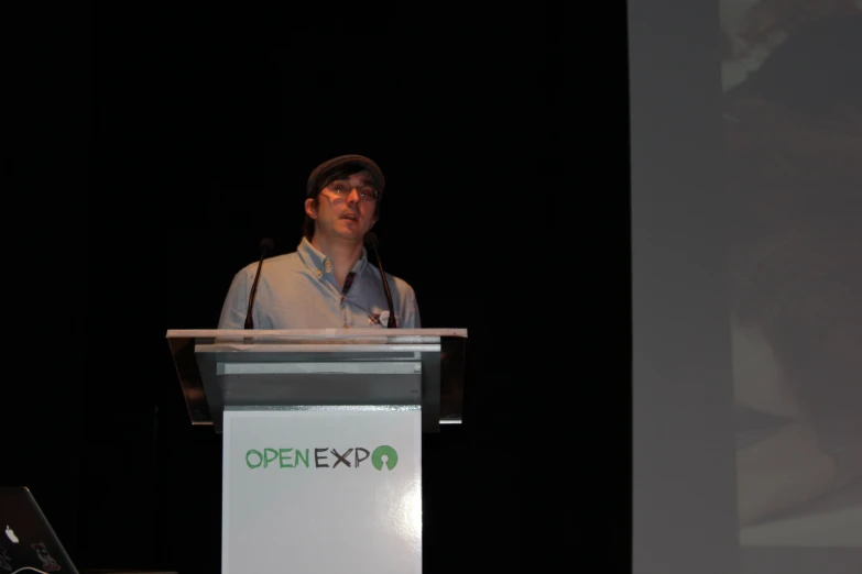 a man standing at a podium with a laptop