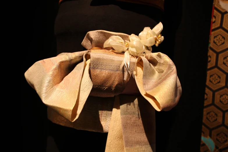 a flower rests atop a piece of gold cloth