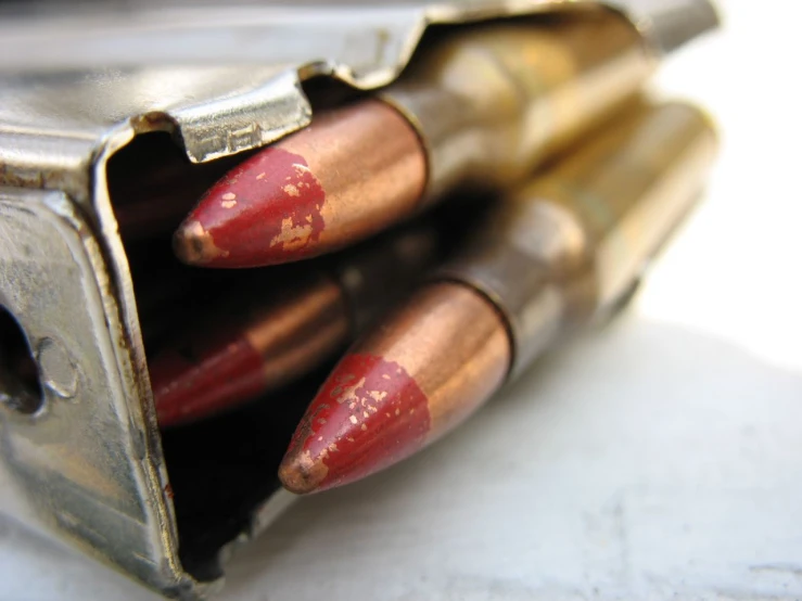 four bullet shells in an empty metal box