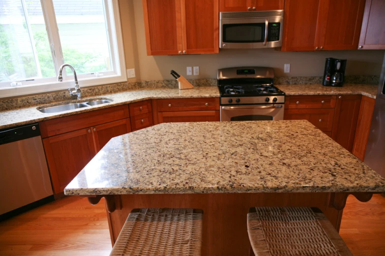 a kitchen with wooden cabinets, and brown granite counter tops