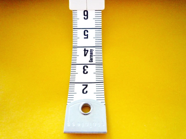 a metal ruler with one end up on yellow paper