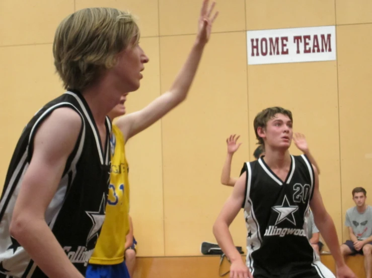 a young man throwing a basketball to another man