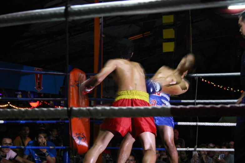 two men are wrestling with the referee in the ring
