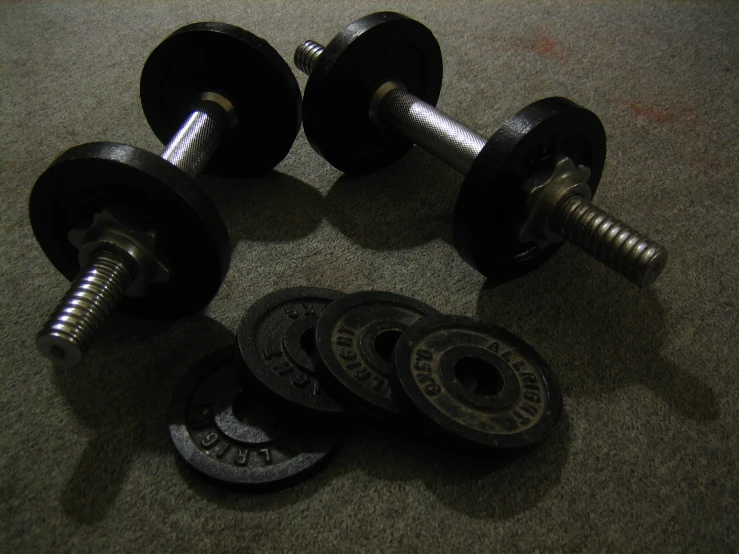 two dumbbells and one weights on the ground