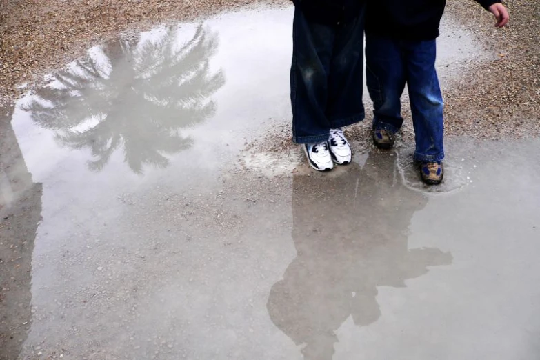 a person walking on a wet, icy surface next to a tree