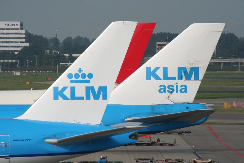 an airport has two plane tails sitting close together
