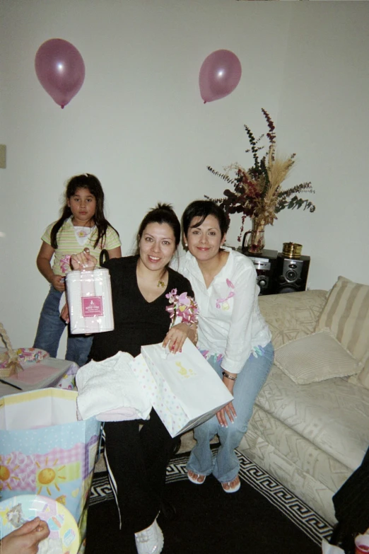 woman holding a wrapped present in front of three children