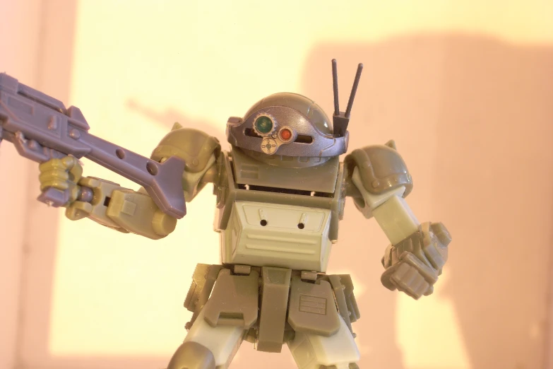 the robot is holding a rifle in one hand and two fingers in another