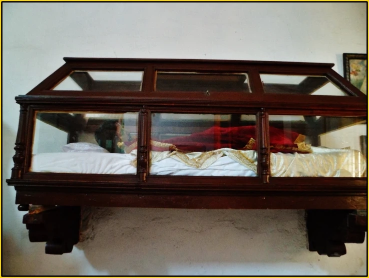 a wooden bench with two people in a glass case